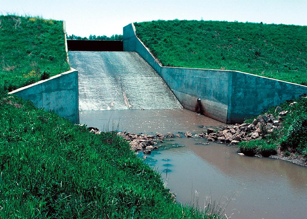 Concrete chute spillway in a dam built as part of a watershed project for flood and erosion control.