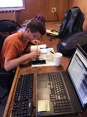 Student working on a map next to a computer