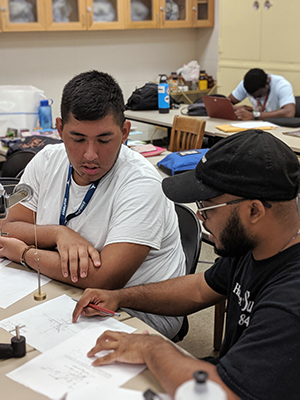 Two students, one mentoring the other