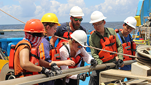 Students on a ship looking at fresh core