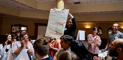 Group celebrating while showing a large drawing