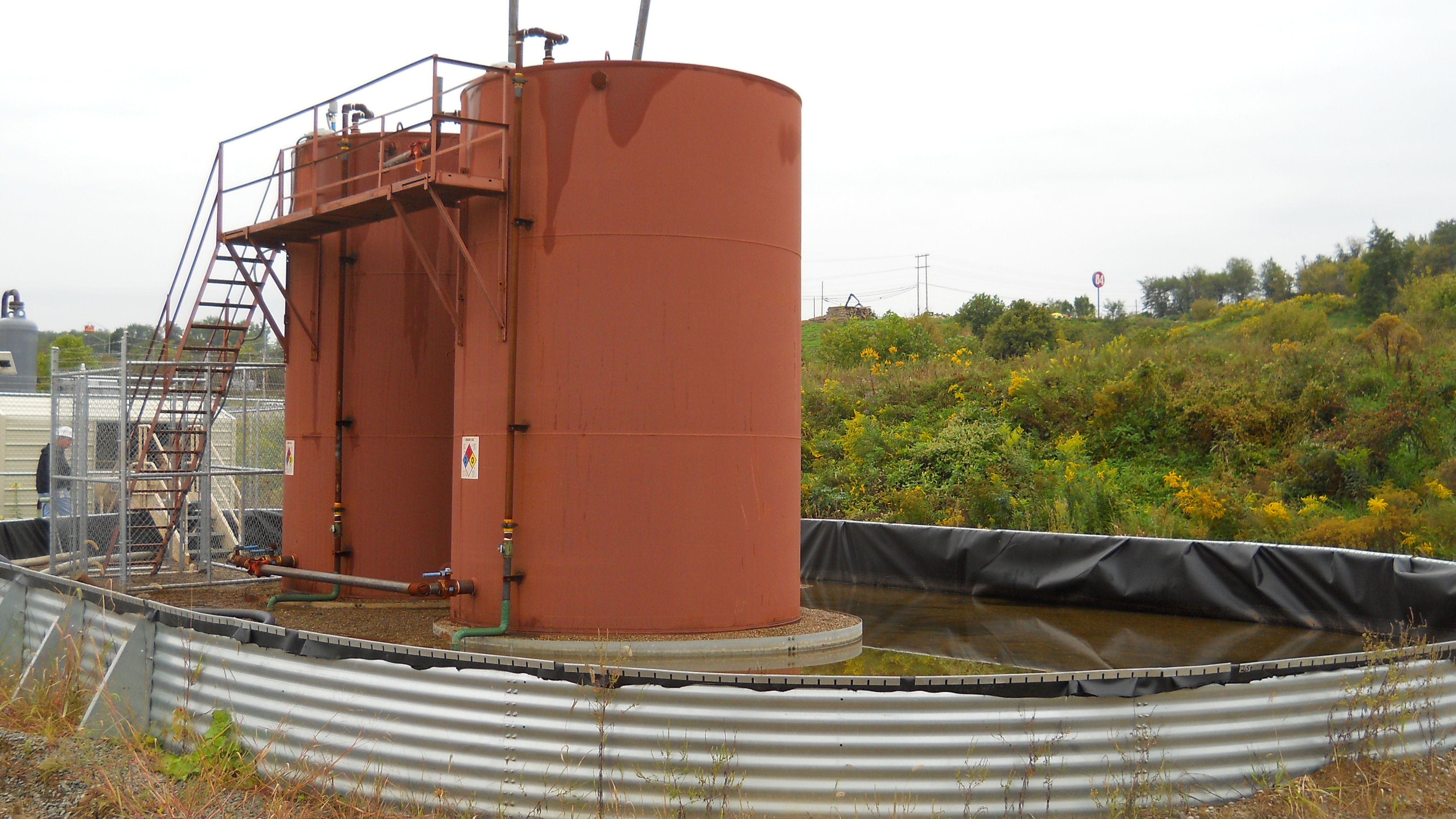 Storage tanks for produced water from natural gas drilling in the Marcellus Shale of Western Pennsylvania are surrounded by spill-containment structures.