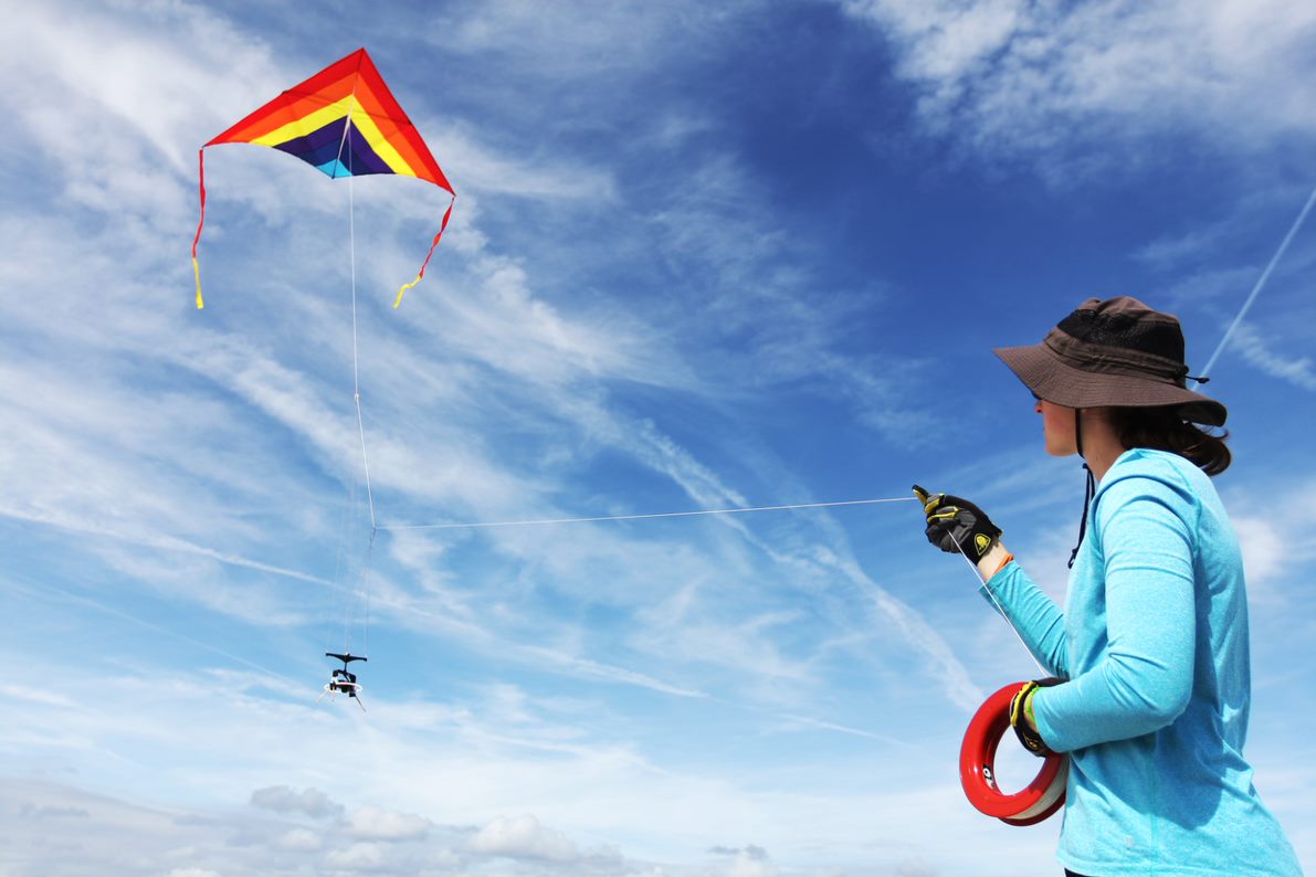A woman guides a kite and drone. Image Credit: Mary Lide Parker 