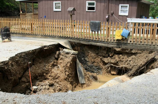 A sinkhole in front of a home in Kentucky. Image Credit: FEMA/Photo by Rob Melendez