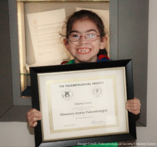 Amery Green holds up her Honorary Junior Paleontologist Certificate