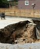 A sinkhole in front of a home in Kentucky. Image Credit: FEMA/Photo by Rob Melendez