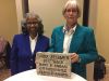 Linda Zellmer (right) and Clara McLeod, stand next to each other in front of a granite rock plaque with *Linda Zellmer 2017 GSIS Mary B. Ansari Distinguished Service Award* carved into it.