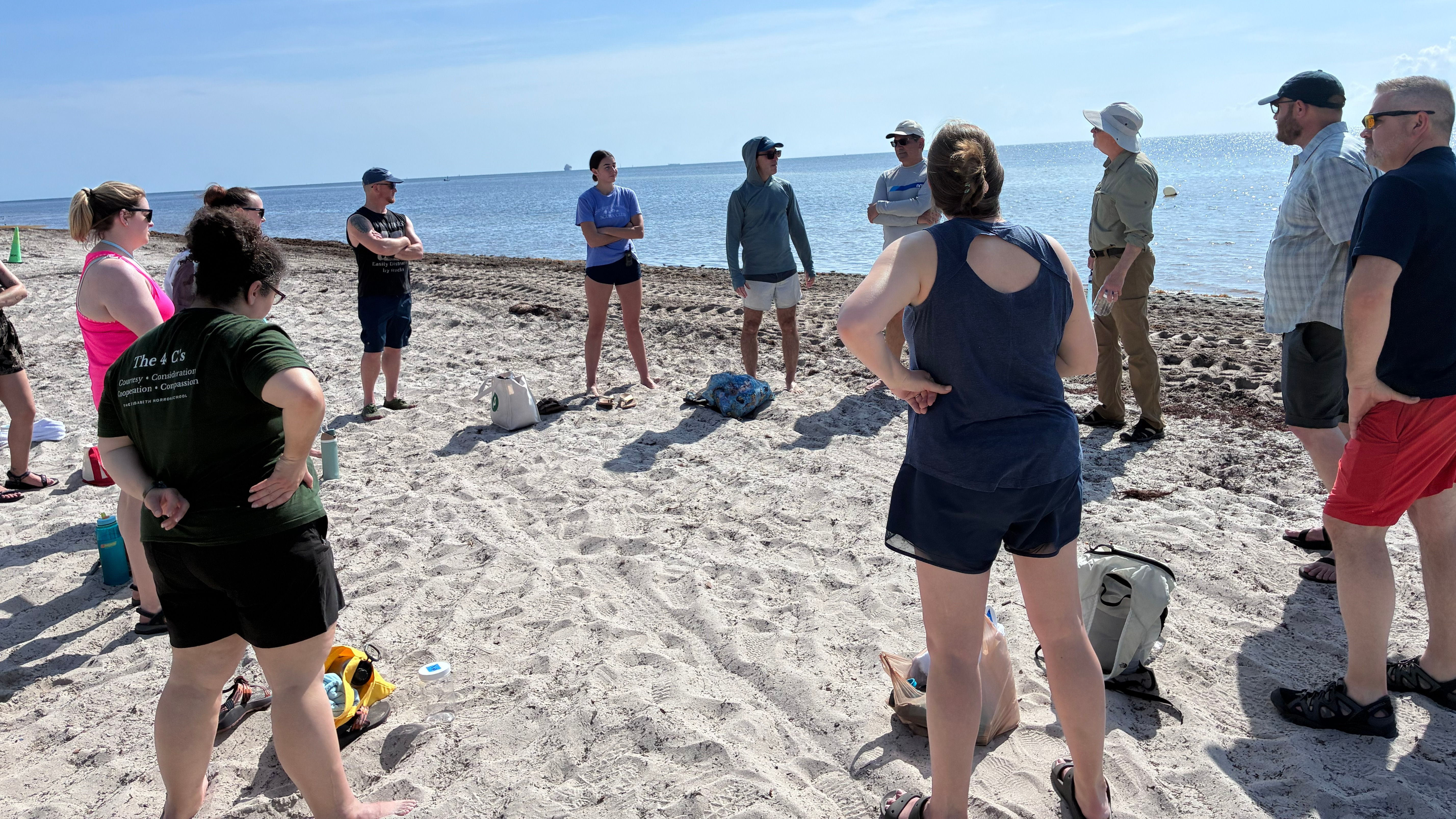 Teachers preparing to collect sand samples on a beach.