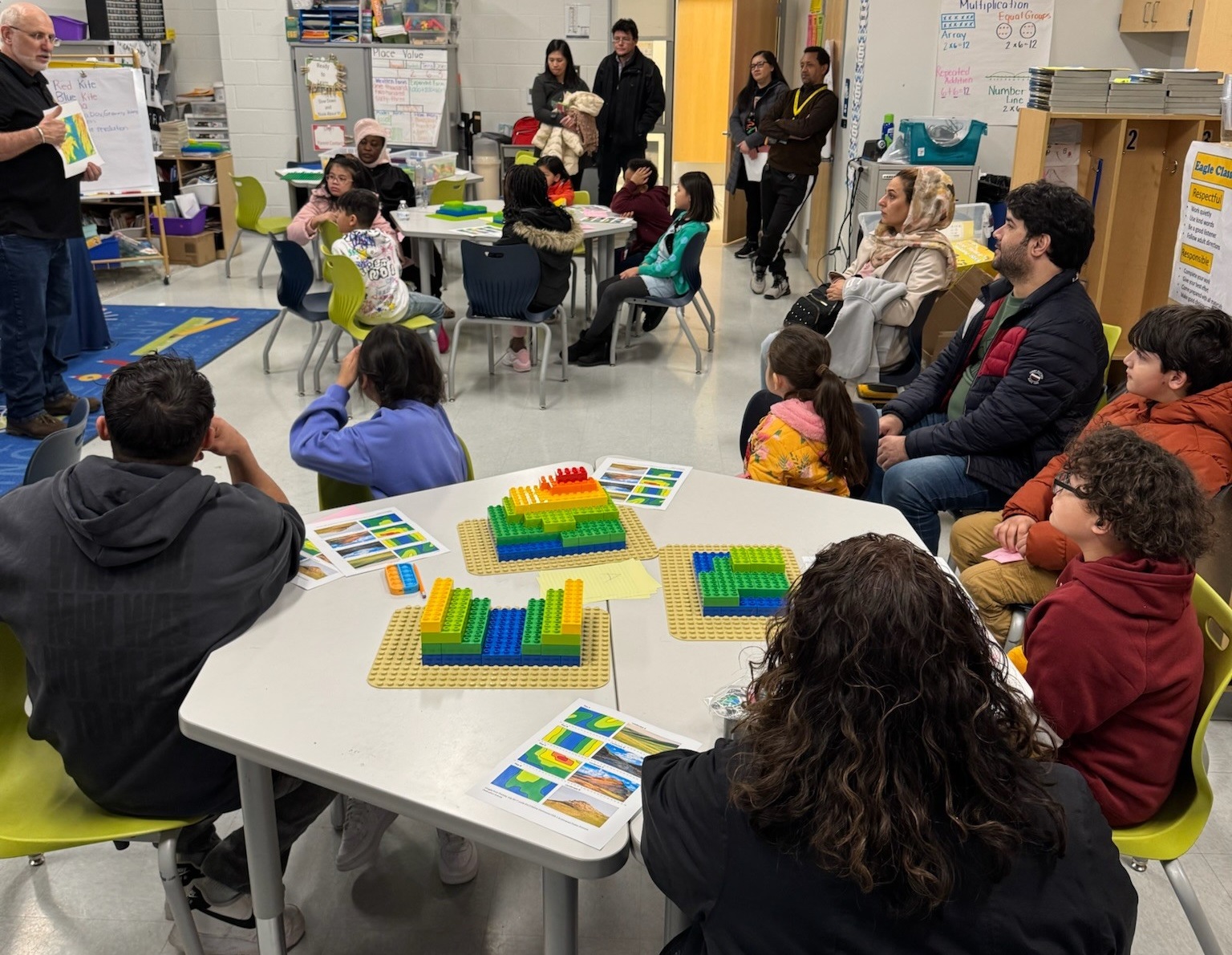 AGU 2024 One of AGI's Education and Outreach staff presenting to elementary students and their parents about topographic maps.