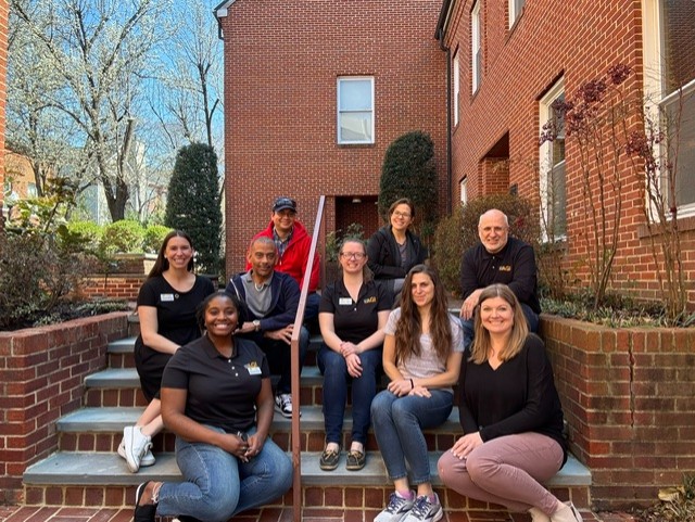 AGI facilitators and teachers sitting in front of AGI headquarters